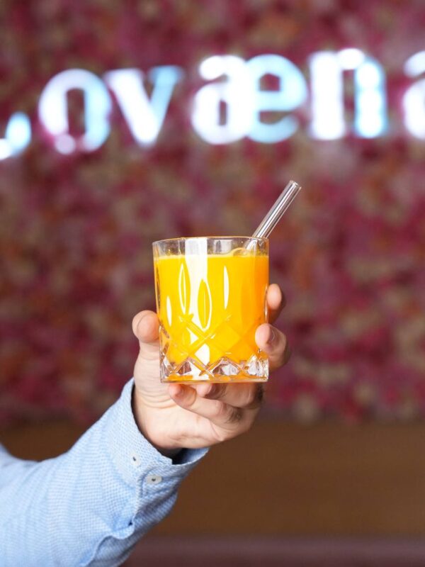 Frischer Orangensaft in einem eleganten Kristallglas bei Lovaena serviert